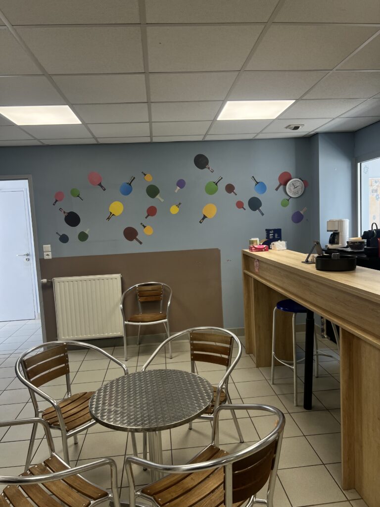 Espace détente de la salle, avec tables, chaises et bar